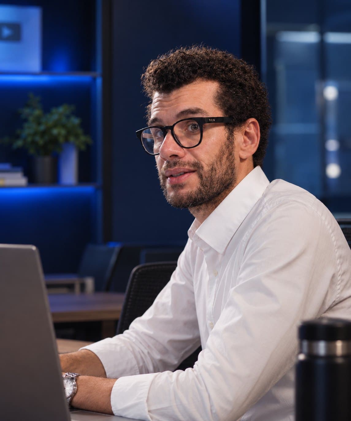 Tiago Feitosa, professor da T2 Educação, sorrindo à mesa com o notebook